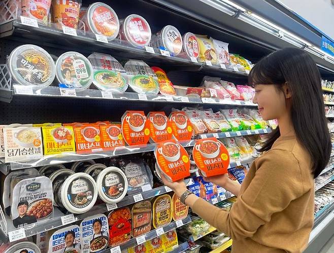 /GS25GS25에서 모델이 마녀스프 시리즈 앞에서 포즈를 취하고 있다