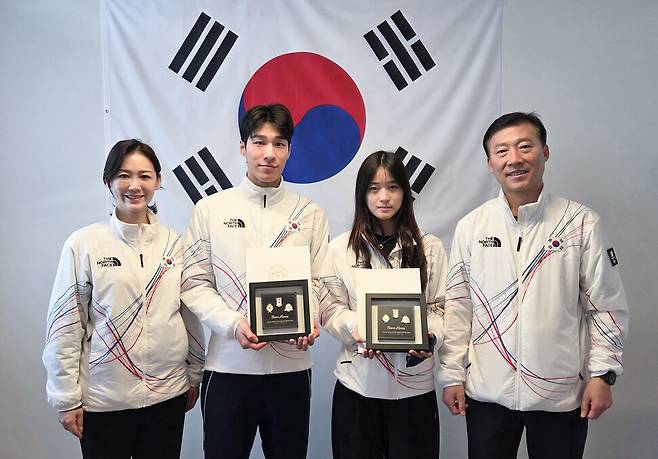 스노보드 여자 하프파이프에서 금메달을 차지한 최가온과 쇼트트랙 남자 1500m 은메달을 획득한 황대헌이 15일(현지시간) 이탈리아 밀라노 선수촌에서 이수경 선수단장과 김택수 부단장에게 이재명 대통령 축전을 받은 뒤 기념 촬영하고 있다. 대한체육회 제공