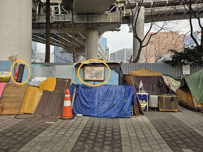 지난 4일 서울역 서부에 위치한 텐트촌의 모습. 최근 이어진 한파로 노숙인들이 추위를 막기 위해 나무 판자와 박스, 천막 등으로 텐트 주변을 보강한 모습. 주변엔 생활에 필요한 빨래건조대 등 생활용품이 널브러져 있었고 외벽엔 글귀와 그림이 쓰여진 액자와 벽시계 등이 걸려있었다. /사진=김영리 기자