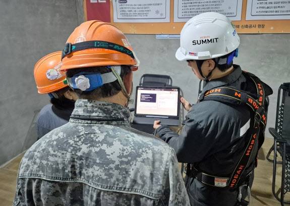 호반건설 직원들이 건설 현장에서 AI 동시번역 플랫폼 ‘호반커넥트’를 활용해 근로자들과 대화하고 있는 모습. 호반그룹 제공