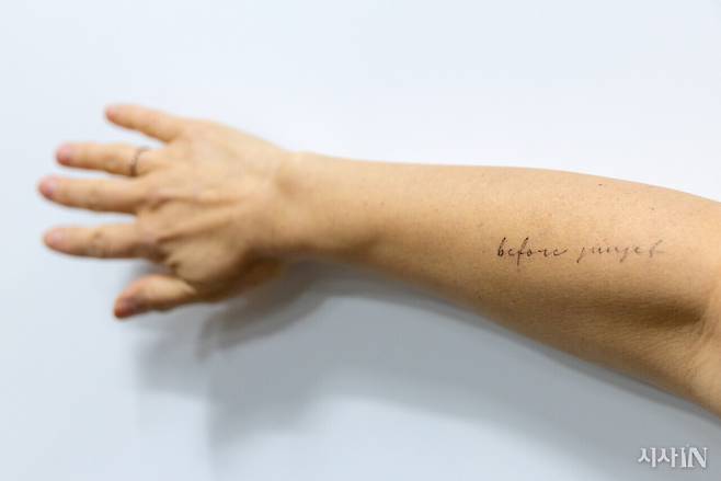 은유 작가가 오른팔에 새긴 레터링 타투. ‘비포 선셋’은 글쓰기의 시작을 떠올리게 하는 문구다. ⓒ시사IN 신선영