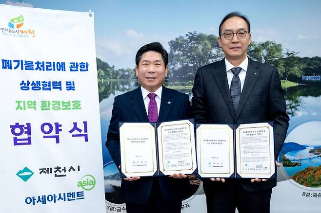 김창규 제천시장(왼쪽)과 최병준 아세아시멘트 본부장이 제천시청에서 수도권 종량제 생활폐기물 반입 차단을 위한 협약을 체결한 뒤 기념사진을 찍고 있다(제천시 제공)
