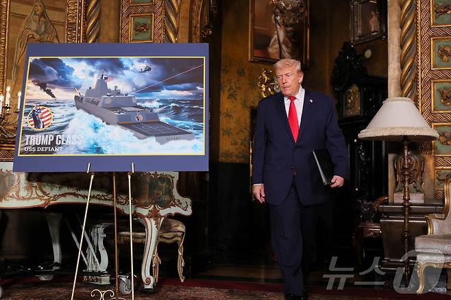 22일(현지시간) 도널드 트럼프 미국 대통령이 플로리다주 팜비치 마러라고에서 해군의 신형 '황금 함대'(Golden Fleet) 관련 '트럼프급' 전투함 USS 데이펀트의 조감도를 지나고 있다. 2025.12.22. ⓒ 로이터=뉴스1