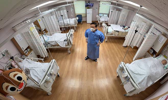 서울의 한 요양 병원 6인실의 간병인(가운데)이 지난달 21일 오전 환자들을 돌보다 잠시 숨을 돌리고 있다. 우리나라에서 간병을 받는 노인이 100만명이 넘는다는 연구 결과가 잇따라 나오고 있지만, 간병비는 여전히 환자와 가족의 몫으로 남아 있다./장련성 기자