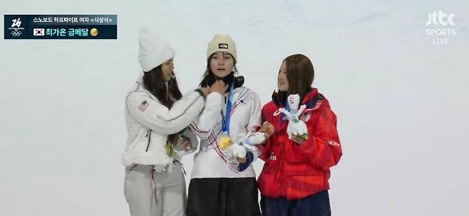포디움에서 클로이 김(왼쪽)이 최가온(가운데)의 넥워머를 내려줬다. 앞서 2차례 올림픽을 제패해 경험 많은 클로이 김이 최가온의 얼굴이 잘나올 수 있도록 배려해준 거다. 사진 JTBC 캡처