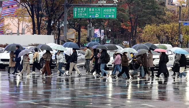 서울 종로구 광화문네거리에서 우산을 쓴 시민들이 출근길을 나서고 있다./2025.11.25 사진=한경 문경덕 기자