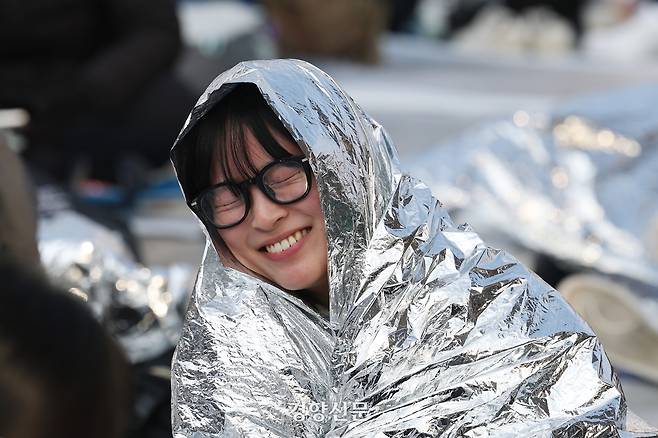 헌법재판소가 윤석열 대통령에 대한 파면을 선고한 지난해 4월4일 전날부터 파면을 촉구하며 밤샘 농성을 이어간 시민들이 서울 종로구 안국역 인근에 방한용 은박비닐을 덮은 채 앉아있다. 정효진 기자