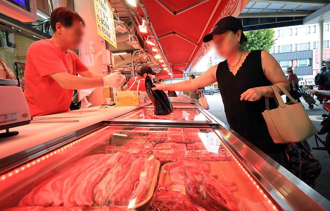 A shopper buys meat at a butcher’s shop in a traditional market in Seoul on Sept. 2, 2025. [NEWS1]