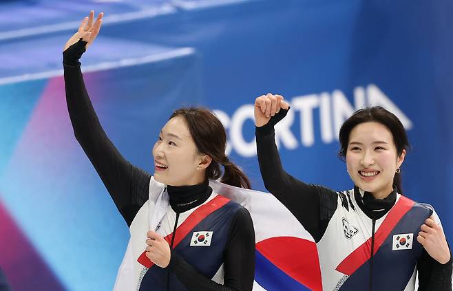 19일 이탈리아 밀라노 아이스스케이팅 아레나에서 열린 2026 밀라노-코르티나 동계올림픽 쇼트트랙 여자 3000m 계주에서 금메달을 따낸 한국대표팀 최민정(왼쪽)과 김길리가 태극기를 둘러멘 체 트랙을 돌며 관중들의 환호에 답하고 있다. [연합]