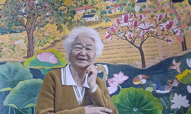 85세에 목원대 미술학부를 졸업한 늦깎이 대학생 이군자씨가 자신의 작품 앞에서 환한 미소를 짓고 있다. 목원대 제공