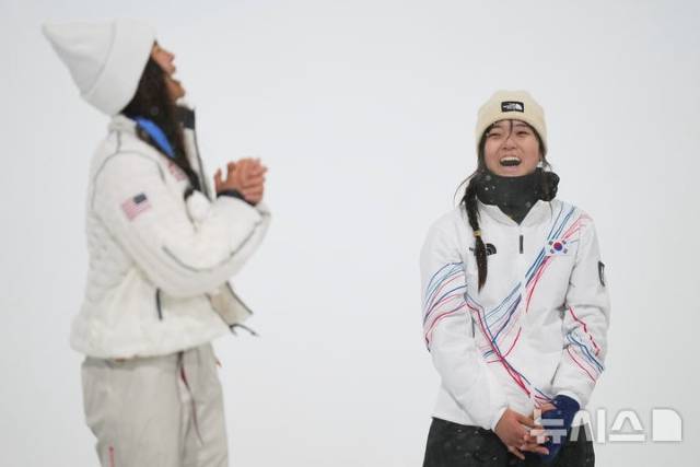 바로 이 장면! 최가온(오른쪽)이 지난 12일(현지 시간) 2026 밀라노 코르티나담페초 동계올림픽 스노보드 여자 하프파이프 금메달을 목에 걸고 웃음 짓고 있다. 강력한 우승후보이자 자신의 멘토인 클로이 김(왼쪽)을 제치고 정상에 올랐다. 최가온은 클로이 김의 최연소 금메달 기록도 경신했다. 이 시상식에서 최가온은 애국가가 흘러나오자 눈물을 흘렸고, 클로이 김은 아낌없이 축하를 보냈다./ 뉴시스