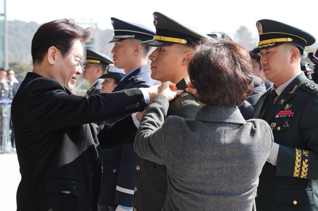 이재명 대통령이 20일 충남 계룡대 대연병장에서 열린 육·해·공군 사관학교 통합임관식에서 임관 장교들에게 계급장을 달아주고 있다. 연합뉴스