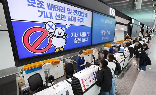 부산 강서구 김해국제공항 에어부산 탑승 수속 카운터에 보조배터리 기내 사용 및 충전 금지 안내문이 게시되어 있다. ⓒ 연합뉴스