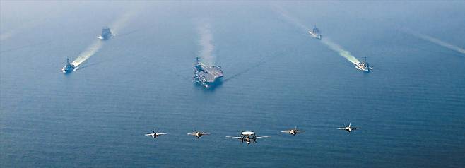 트럼프, 평화위 첫 회의… 美 항모전단 무력 시위… 도널드 트럼프 미국 대통령이 19일 워싱턴 DC 미국평화연구소에서 열린 평화위원회 첫 이사회 회의에서 의사봉을 들고 있다(위쪽 사진). 트럼프는 이 회의에서 “이란이 미국과의 핵 협상에서 합의에 이르지 못할 경우 나쁜 일이 일어날 것”이라고 경고했다. 미국은 이란을 압박하기 위해 2003년 이라크전 이후 최대 규모의 군사력을 중동에 전개했다. 아래쪽 사진은 미 해군 에이브러햄 링컨 항모 전단이 지난 6일 아라비아해 북부 해역을 항해하는 모습./AFP·로이터 연합뉴스