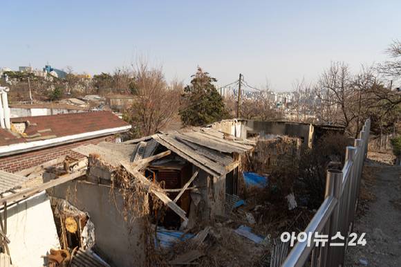 성북구 정릉골 내 이주를 마치고 오랜 시간이 지나 무너진 집들 뒤로 아파트들 전경이 보이고 있다.  [사진=김민지 기자]