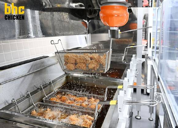 bhc 튀김로봇 '튀봇'이 치킨을 조리하고 있다. [사진=교촌치킨 bhc]