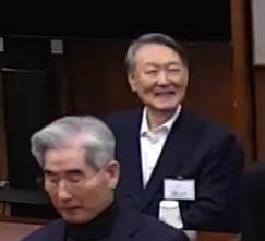 내란 우두머리 혐의를 받는 윤석열 전 대통령이 19일 서울 서초구 서울중앙지법에서 열린 1심 선고공판에 출석해 웃고 있다. 2026.2.19. 서울중앙지법 제공