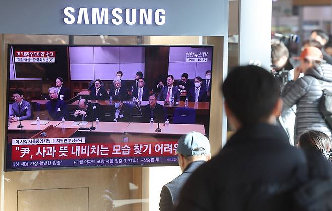 12·3 비상계엄과 관련해 내란 우두머리 혐의로 기소된 윤석열 전 대통령에 대한 1심 선고가 열린 지난 19일 서울역에서 시민들이 관련 뉴스를 보고 있다. [연합뉴스]