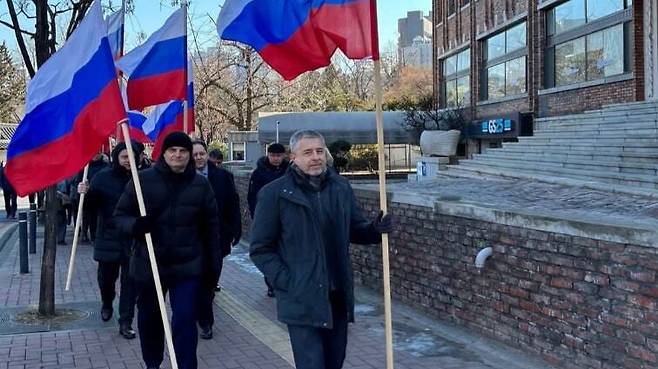 우크라이나 침공 3주년이었던 지난해 2월 24일 게오르기 지노비예프 주한 러시아 대사(맨 앞)가 대사관에서 나와 전쟁 지지 집회를 개최한 후, 대형 러시아기를 들고 대사관까지 행진하고 있다./주한 러시아 대사관 페이스북