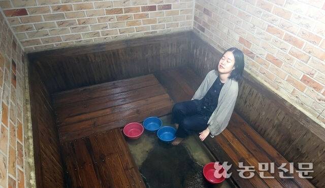 전남 함평에서 뜨거운 유황돌과 숯을 넣어 증기가 피어오르는 탕 속에서 기자가 해수찜을 체험하고 있다. 함평=김도웅 프리랜서 기자
