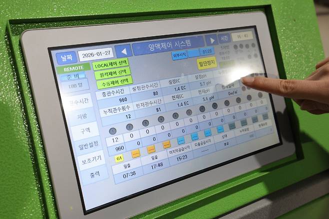 한 직원이 양액제어 시스템을 확인하고 있다.