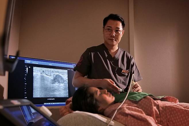 유방초음파 검사를 시행 중인 박성문 원장. 그는 환자들이 초음파 검사 결과에 대해 이해하기 쉽도록 동일한 화면을 볼 수는 환자용 모니터를 도입했다.