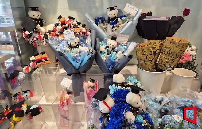 지난 20일 신촌역 인근 한 꽃집에 졸업식 축하용 꽃다발이 진열돼있다. 학사모를 쓴 곰인형이나 비누꽃이 인기 상품으로 꼽혔다. 오지은 기자