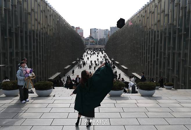 이화여대 교정에서 한 졸업생이 학사모를 던지고 있다.