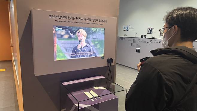A visitor watches video of BTS Jimin displayed within the National Museum of Korean Contemporary History in Jongno District, central Seoul. [WOO JI-WON]