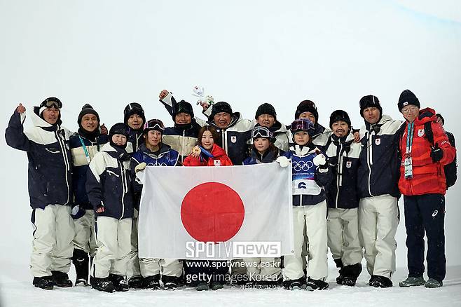 ▲ 이탈리아 리비뇨 스노우 파크에서 열린 밀라노-코르티나 동계 올림픽 6일째 여자 스노보드 하프파이프 시상식에서 동메달리스트인 일본 대표팀 오노 미츠키가 팀 동료인 토미타 세나, 쿠도 리세, 시미즈 사라, 그리고 스태프들과 함께 일본 국기를 들고 기념사진을 찍고 있다.
