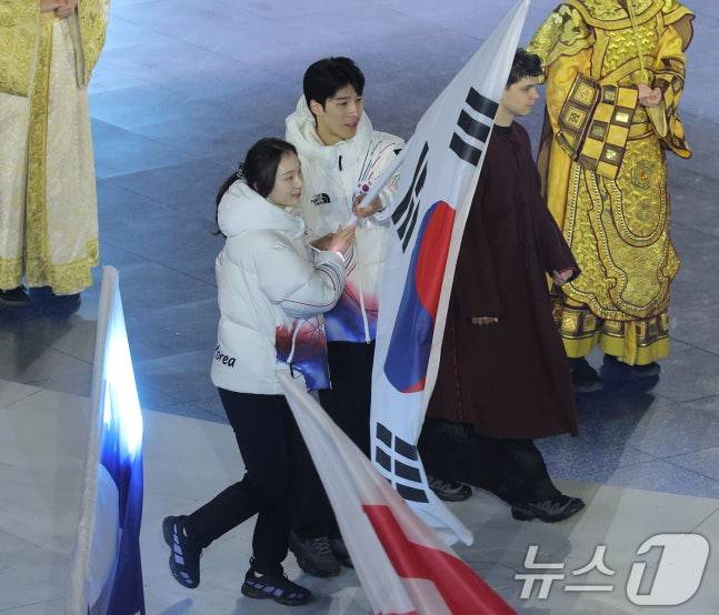 22일(현지시간) 이탈리아 베로나 올림픽 아레나에서 열린 2026 밀라노·코르티나담페초 동계올림픽 폐회식에서 대한민국 선수단 기수를 맡은 쇼트트랙 최민정(왼쪽)과 황대헌이 입장하고 있다. /사진=뉴스1(공동취재)