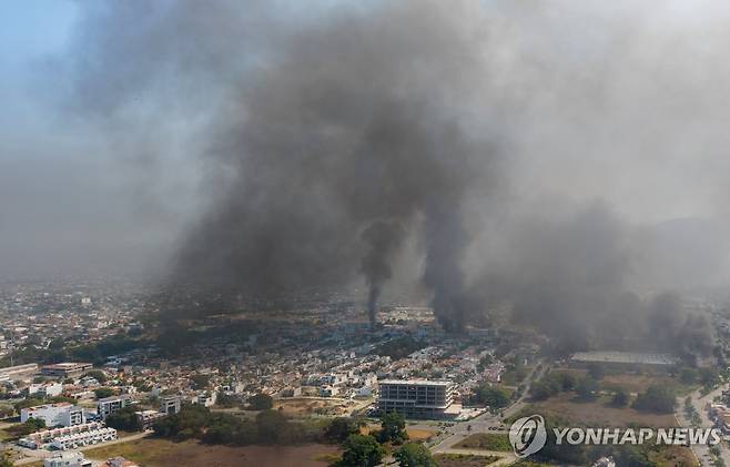22일 멕시코 푸에르토 바야르타에서 폭력사태 후 연기가 피어오르는 모습 [EPA=연합뉴스. 재판매 및 DB 금지]