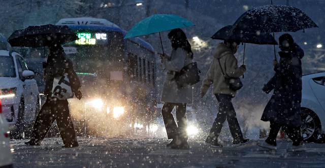 대구에 대설주의보가 발효되며 많은 눈이 내린 24일 대구 북구 산격동에서 퇴근길 시민들이 발걸음을 재촉하고 있다. 김영진 기자 kyjmaeil@imaeil.com