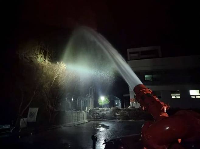 23일 오후 경남 밀양시 삼량진읍 산불 현장 인근 요양병원에 대용량포방사시스템을 배치해, 산불 확산에 대비한 대규모 예비주수를 실시하고 있다. 소방청