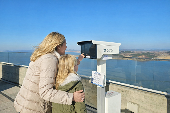 김포 애기봉에 설치한 '보라' 망원경으로 외국 관광객들이 북한의 모습을 지켜보고 있다.[사진=오썸피아 제공]