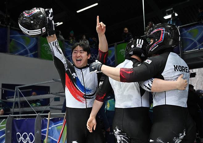 Kim Jin-su, Kim Hyeong-geun, Lee Geon-u and Kim Sun-wook celebrate after its last four man bobsled run at the 2026 Winter Olympics in Cortina d'Ampezzo, Italy, on Feb. 22. [AP/YONHAP]
