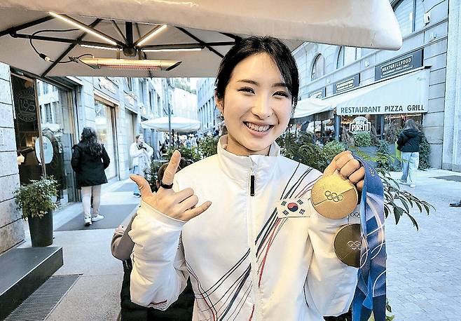 쇼트트랙 국가대표 김길리가 21일(한국시간) 이탈리아 밀라노 시내의 한 카페에서 매일경제와 단독 인터뷰한 뒤 자신이 따낸 금메달 2개를 들어 보이며 시그니처 포즈를 취하고 있다. 김길리는 "(포즈는) 내 느낌을 표현한 것"이라고 밝혔다.  밀라노 김지한 기자