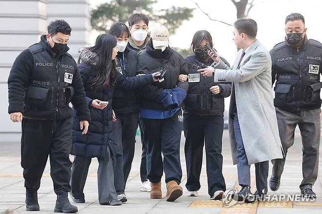 서울 강북구 수유동 모텔에서 남성 2명을 숨지게 한 혐의를 받는 20대 여성 A씨가 지난 12일 서울북부지법에서 영장실질심사를 받기 위해 출석하고 있다. 경찰에 따르면 A씨는 9일 강북구 수유동의 한 모텔에서 20대 남성 B씨에게 약물이 든 음료를 건네 숨지게 한 혐의를 받는다. [연합뉴스]