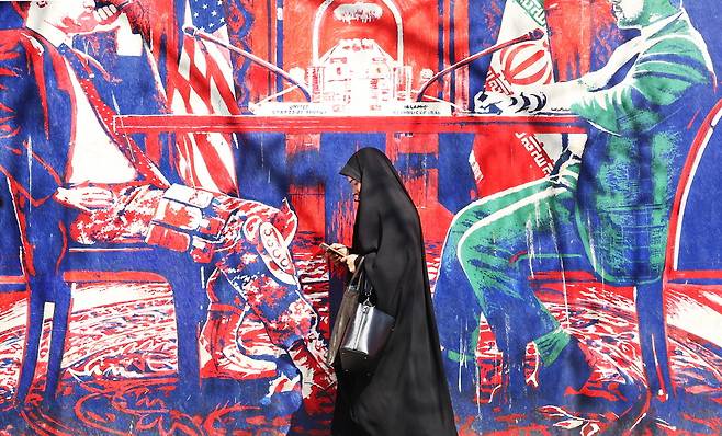 미국·이란 '최후의 담판'23일(현지시간) 이란 테헤란에서 히잡을 쓴 한 이란 여성이 미국과 이란의 협상 모습을 그린 벽화 앞을 지나가고 있다. 스티브 윗코프 중동 특사는 26일 스위스 제네바에서 이란과 핵 협상을 재개할 예정이다. 이번 협상은 미국의 대이란 공격 여부를 결정하는 마지막 협상이 될 것이라는 관측이 나온다.  EPA연합뉴스