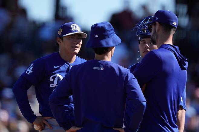 LA 다저스 야마모토가 22일 시범경기 LA 에인절스전 2회 도중 포수, 코치와 함께 마운드에서 대화를 나누고 있다. AP연합뉴스