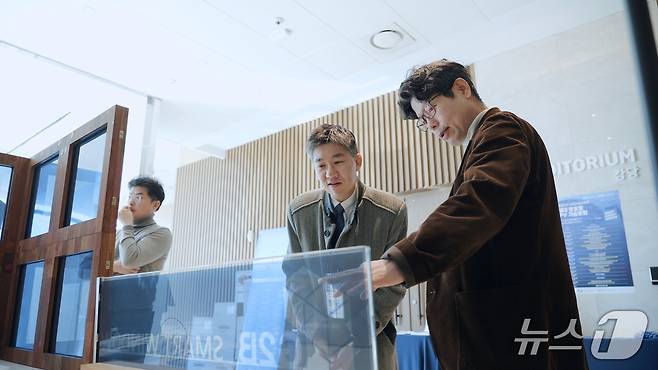 25일 부산 남구 부산국제금융센터(BIFC)에서 열린 차세대 창호형 BIPV 기술포럼에서 참가자가 지능형 조절 특성을 가진 스마트 유리 제품 시연을 보고 있다. ⓒ 뉴스1