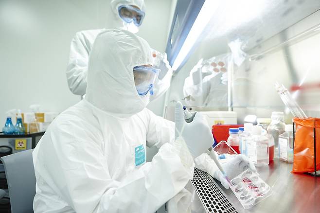 방호복을 착용한 고려대의료원 연구진이 실험실에서 연구를 수행하고 있다.