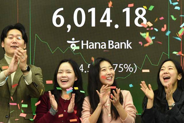 코스피 지수가 장 시작과 함께 6,000포인트를 돌파한 25일 서울 중구 하나은행 본점 딜링룸 전광판 앞에서 직원들이 기뻐하고 있다. 윤기훈 인턴기자