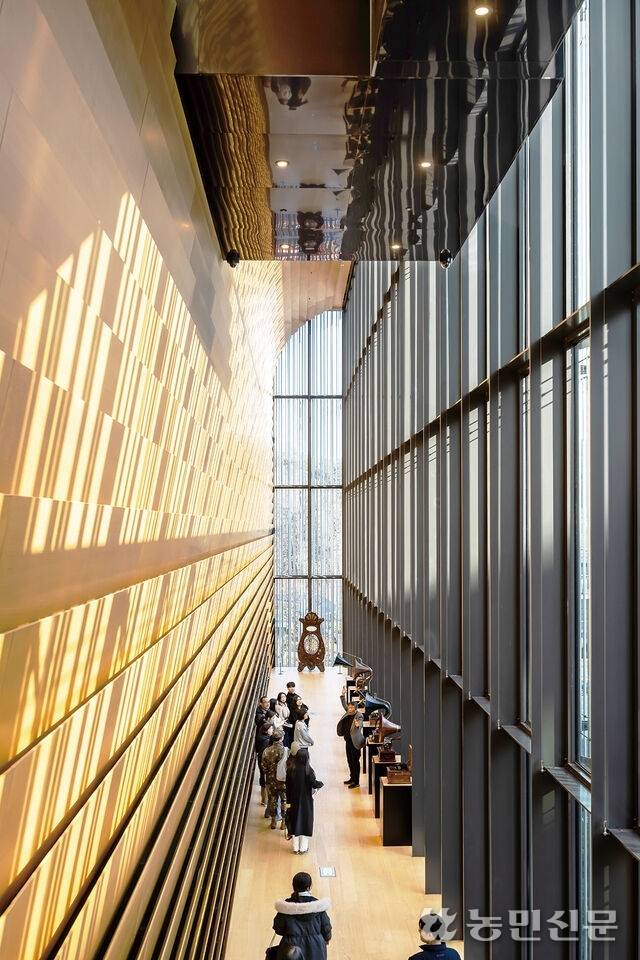 전시홀의 편백나무 루버에 알루미늄 파이프의 그림자가 비친 모습.