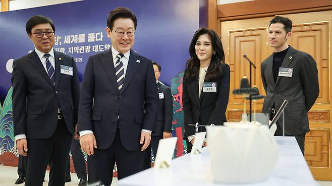 이재명 대통령이 2025 관광기념품 공모전 수상작을 보고 있다.