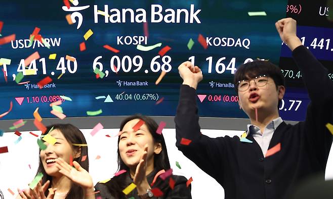 (서울=뉴스1) 최지환 기자 = 코스피 지수가 장 시작과 함께 6000포인트를 돌파한 25일 오전 서울 중구 하나은행 본점 딜링룸 직원들이 기뻐하고 있다. 2026.2.25/뉴스1