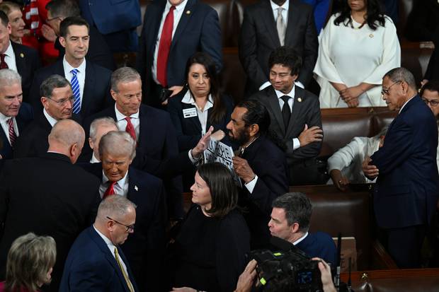 도널드 트럼프 대통령이 24일(현지 시간) 워싱턴 D.C. 미국 국회의사당 하원 본회의장에서 열린 국정연설을 위해 입장하는 동안 앨 그린 하원의원(민주당, 텍사스주)이 “흑인은 원숭이가 아니다”라고 적힌 팻말을 들고 항의하고 있다. 수십 명의 민주당 의원들은 트럼프 대통령의 국정연설에 불참했고, 트럼프 대통령은 민주당을 향해 “미쳤다”고 비난했다. APF연합뉴스