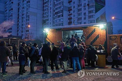 정전으로 난방이 끊긴 우크라이나 키이우에서 시민들이 군부대에서 제공하는 식사를 제공받으려 줄을 서 있는 모습. [AP 연합뉴스 자료사진. 재판매 및 DB 금지]