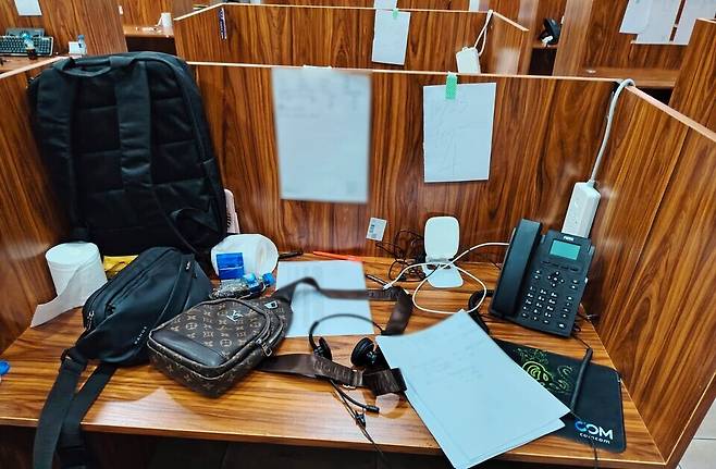 ▲ 라오스 현지에서 적발된 '송남파' 보이스피싱 콜센터 내부 모습. 칸막이가 설치된 책상 위로 범행에 사용된 집기류가 놓여 있다. /사진제공=의정부경찰서