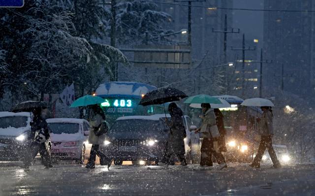 대구지역에 대설주의보가 발효되며 많은 눈이 내린 24일 대구 북구 산격동에서 퇴근길 시민들이 발걸음을 재촉하고 있다. 김영진 기자 kyjmaeil@imaeil.com
